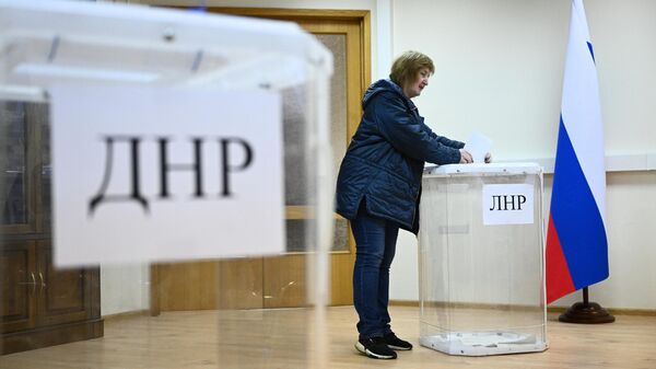Женщина голосует на референдуме о присоединении Донецкой народной республики и Луганской народной республики к России