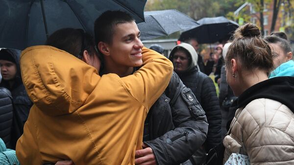 Мужчина, призванный на воинскую службу в ходе частичной мобилизации, прощается с девушкой возле военного комиссариата Кунцевского района Москвы