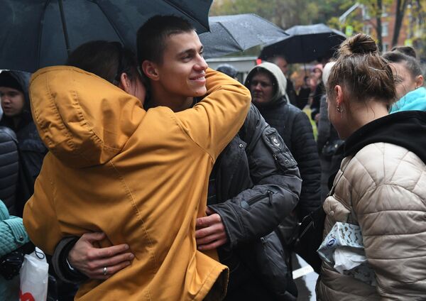 Мужчина, призванный на воинскую службу в ходе частичной мобилизации, прощается с девушкой возле военного комиссариата Кунцевского района Москвы