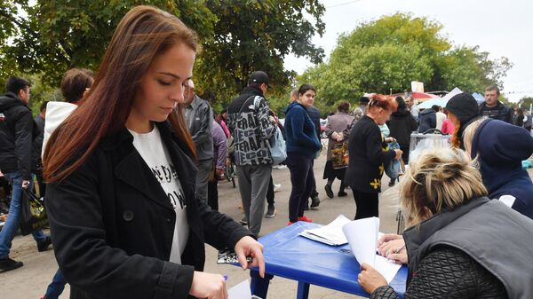 Местная жительница голосует на выездном избирательном участке в Мариуполе