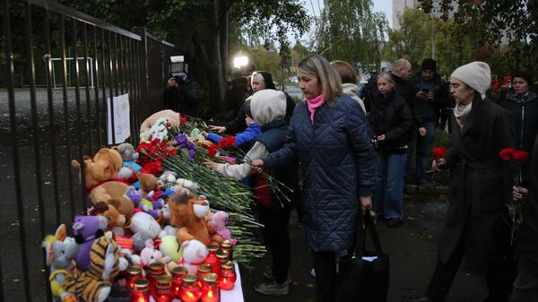 Люди возлагают цветы и игрушки у школы №88 Ижевска