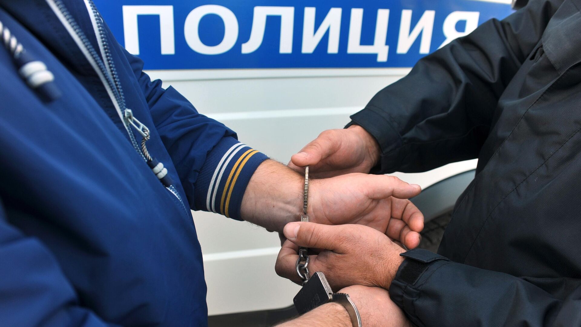 Сотрудник полиции надевает наручники на правонарушителя - РИА Новости, 1920, 13.10.2022