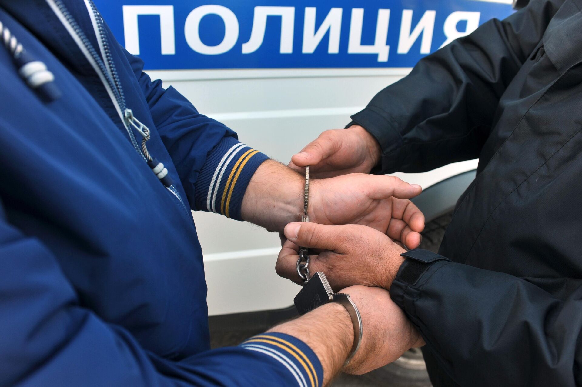 Сотрудник полиции надевает наручники на правонарушителя - РИА Новости, 1920, 25.10.2023