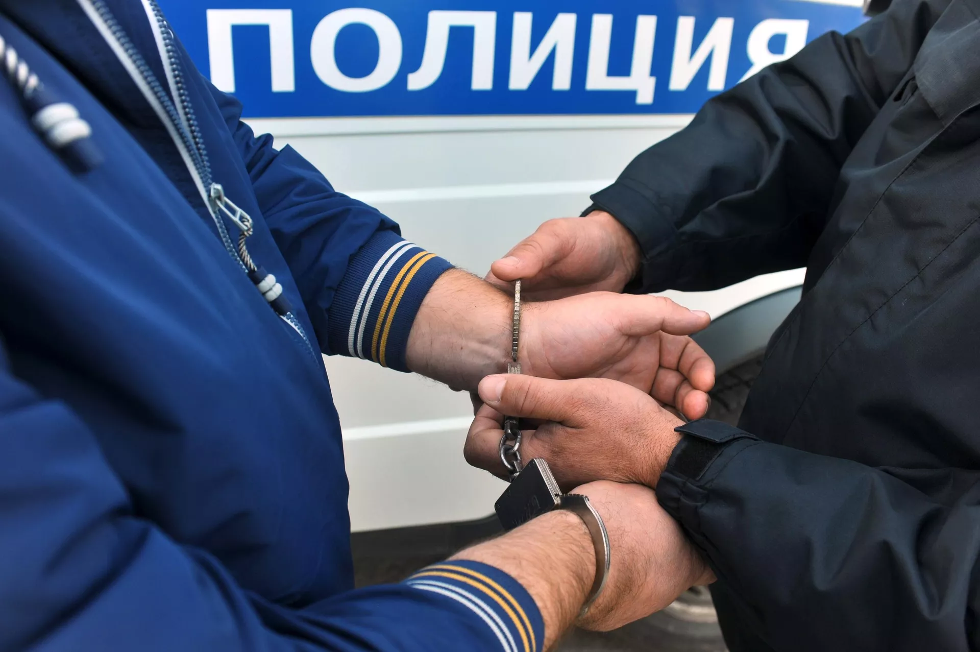 Сотрудник полиции надевает наручники на правонарушителя - РИА Новости, 1920, 26.09.2022