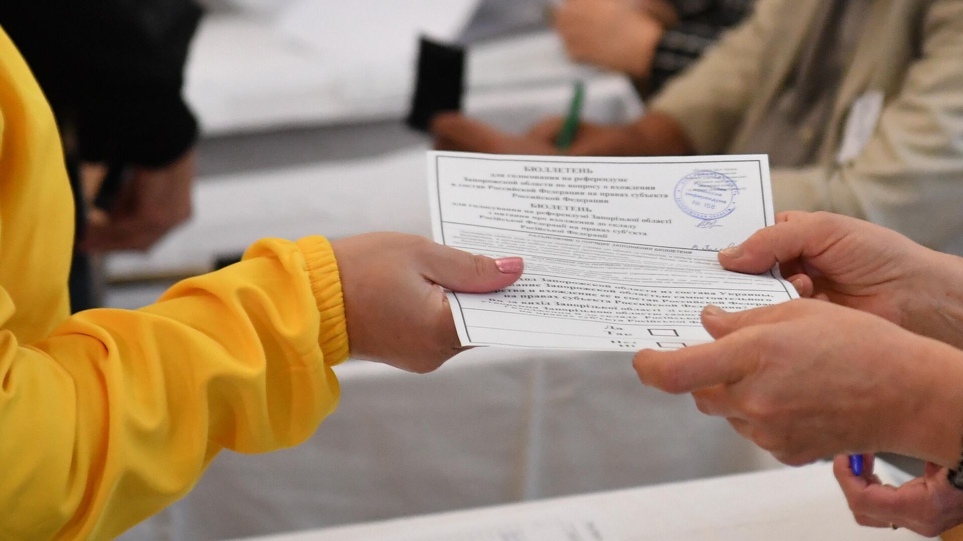 Избиратель получает бюллетень для голосования на референдуме о присоединении к России - РИА Новости, 1920, 27.09.2022