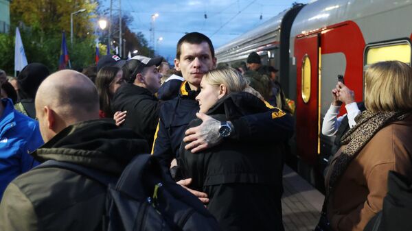 Женщина провожает мужчину, призванного на военную службу в ходе частичной мобилизации, на перроне железнодорожного вокзала в Мурманске