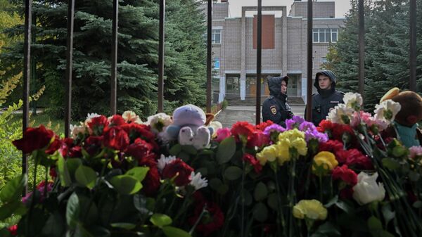 Сотрудники полиции у стихийного мемориала у школы №88 в Ижевске