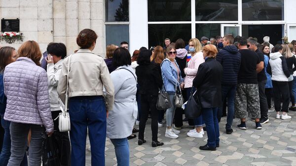 Люди стоят в очереди у избирательного участка в Мелитополе для участия в референдуме о присоединении Запорожской области к России
