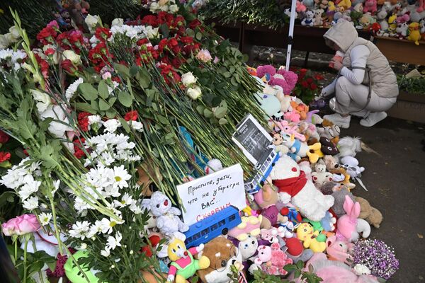 Люди возлагают цветы и игрушки у школы №88 в Ижевске