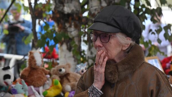 ожилая женщина у стихийного мемориала у школы №88 в Ижевске