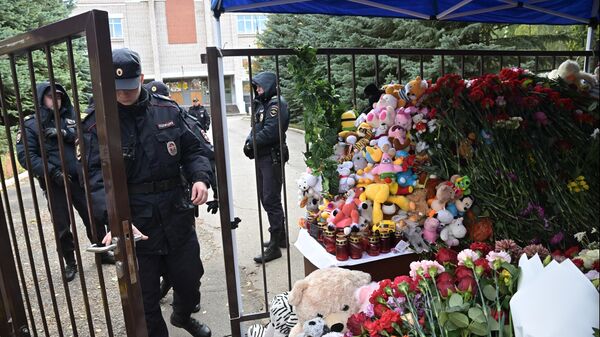 Сотрудники полиции у стихийного мемориала у школы №88 в Ижевске