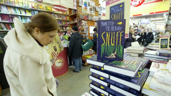 Покупатель рассматривает книги Виктора Пелевина S.N.U.F.F в книжном магазине Библио-Глобус