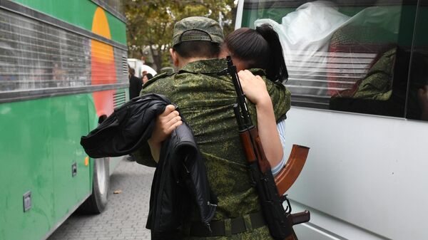 Мужчина, призванный на военную службу в ходе частичной мобилизации, прощается с девушкой на площади Нахимова в Севастополе