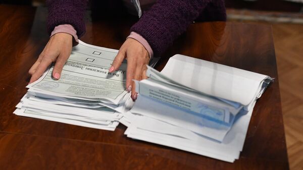 Сотрудница избирательной комиссии на избирательном участке в Донецке считает голоса по итогам референдума по вопросу вхождения ДНР в состав Российской Федерации