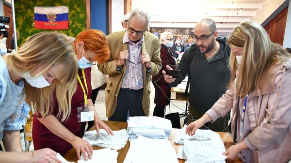 Иностранные наблюдатели следят за подсчетом голосов после закрытия избирательного участка в Мелитополе