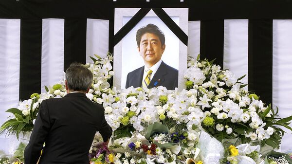 Мужчина у портрета Синдзо Абэ во время церемонии государственных похорон бывшего премьер-министра Японии Синдзо Абэ в Токио