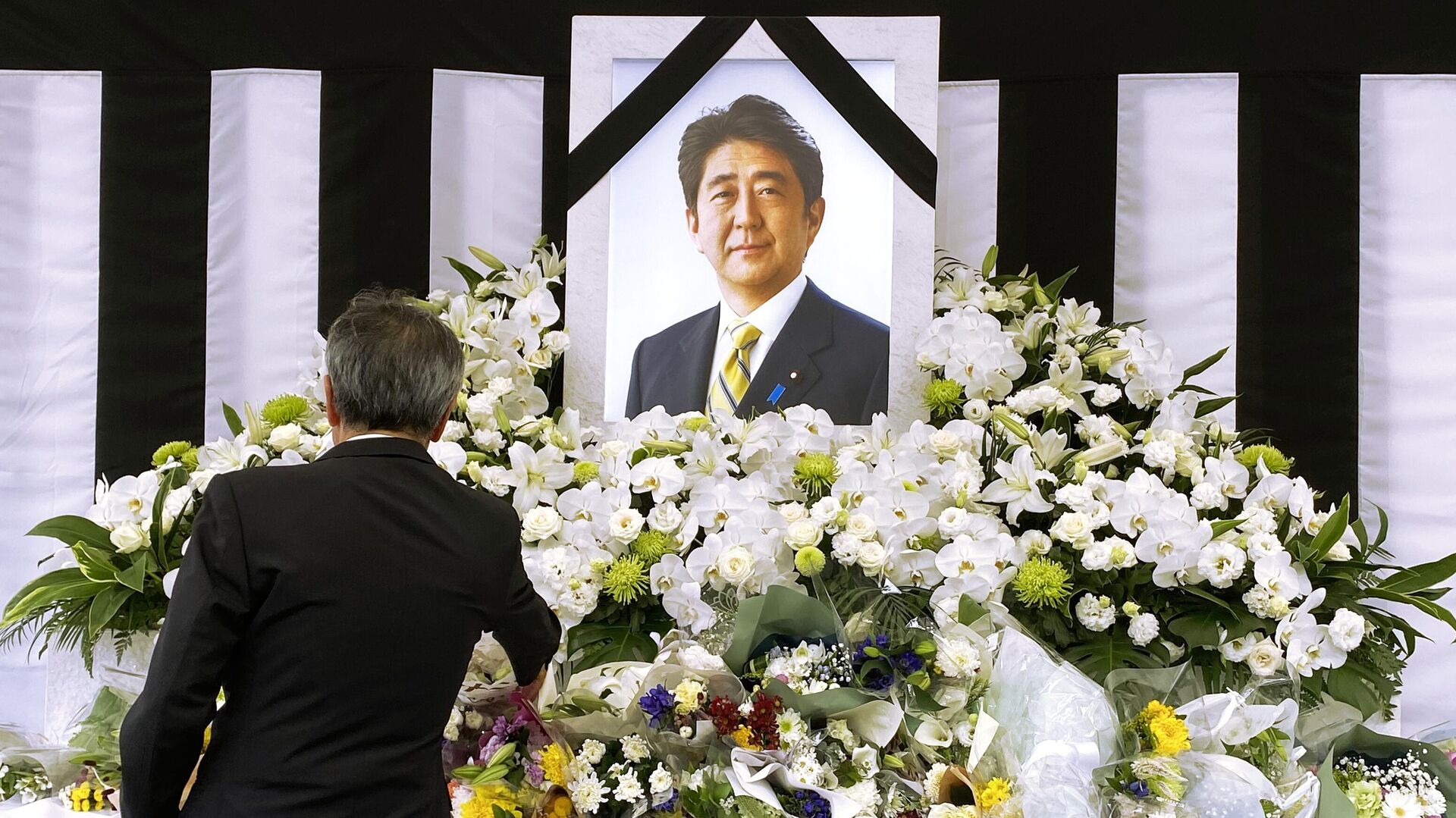 Мужчина у портрета Синдзо Абэ во время церемонии государственных похорон бывшего премьер-министра Японии Синдзо Абэ в Токио - РИА Новости, 1920, 08.07.2023