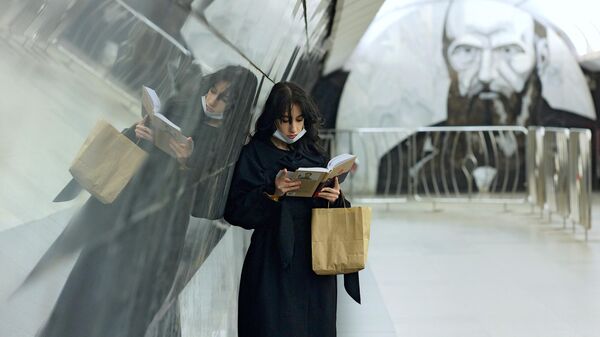 Девушка читает книгу на станции московского метрополитена Достоевская