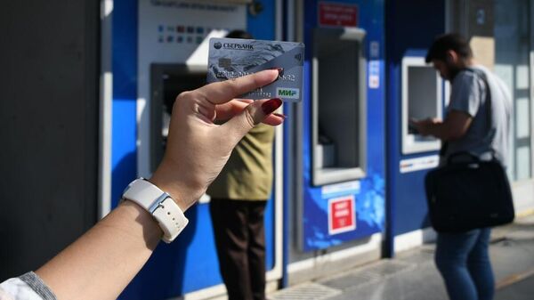 Девушка с картой Мир у банкоматов в Стамбуле