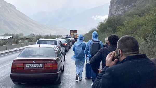 Автомобили и люди на дороге в районе КПП Верхний Ларс на границе России и Грузии