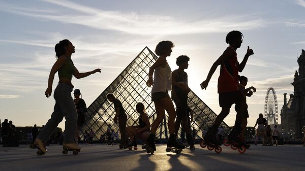 Люди перед пирамидой Лувра в Париже