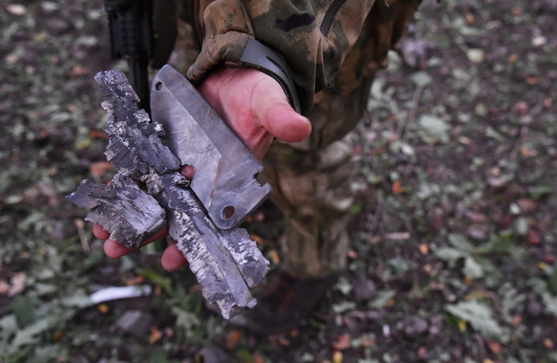 Боец демонстрирует осколки боеприпаса иностранного производства, выпущенного артиллерией ВСУ, на передовой на окраине Красного Лимана в ДНР - РИА Новости, 1920, 30.09.2022