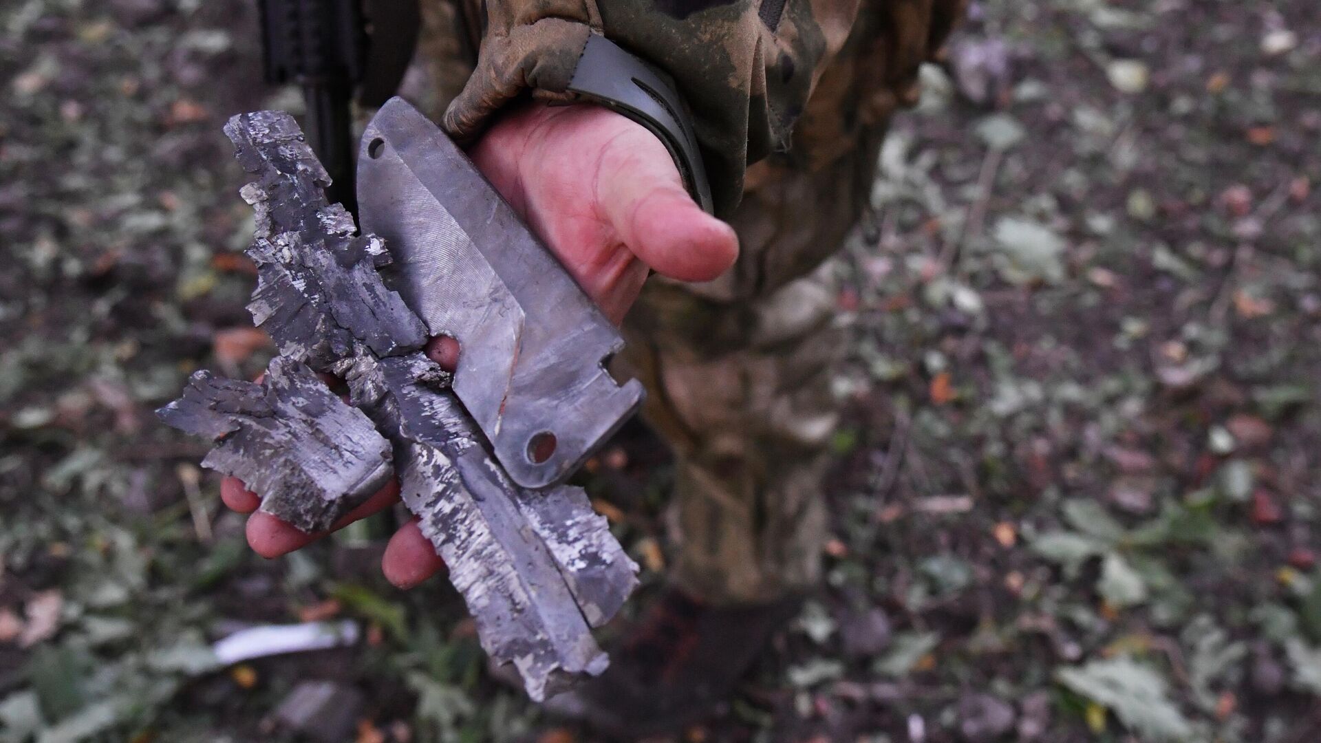 Боец демонстрирует осколки боеприпаса, выпущенного артиллерией ВСУ - РИА Новости, 1920, 09.05.2023