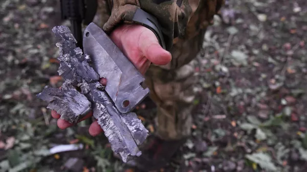 Stíhačka předvádí fragmenty munice zahraniční výroby vypálené dělostřelectvem ozbrojených sil Ukrajiny na frontě na předměstí Krasnyj Liman v DLR