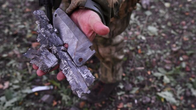 Боец демонстрирует осколки боеприпаса иностранного производства