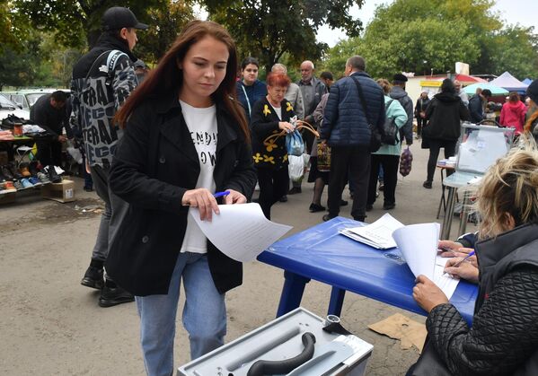 Местная жительница голосует на выездном избирательном участке в Мариуполе