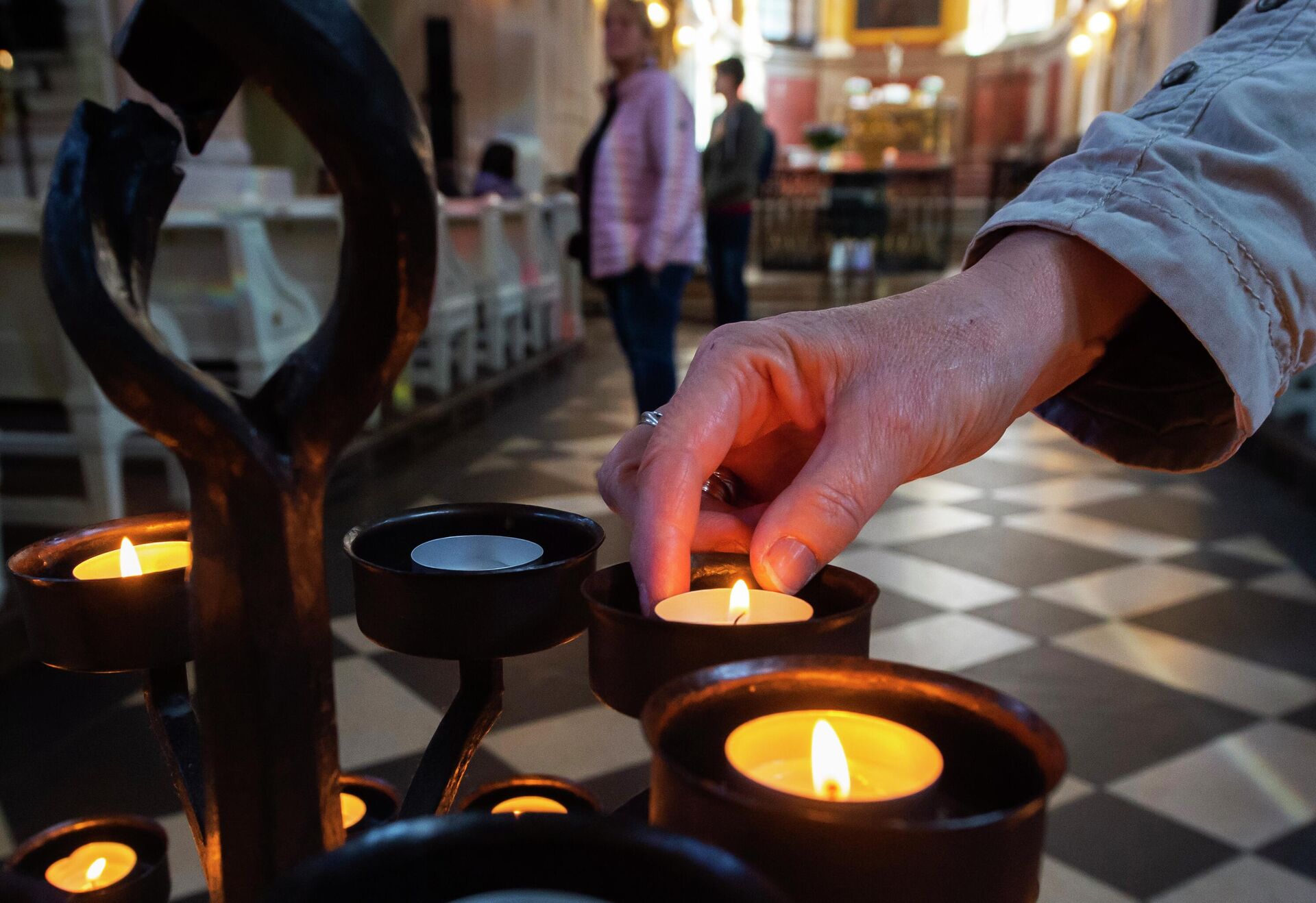 Женщина зажигает свечу в церкви святого Николая в Лейпциге, Германия  - РИА Новости, 1920, 30.09.2022
