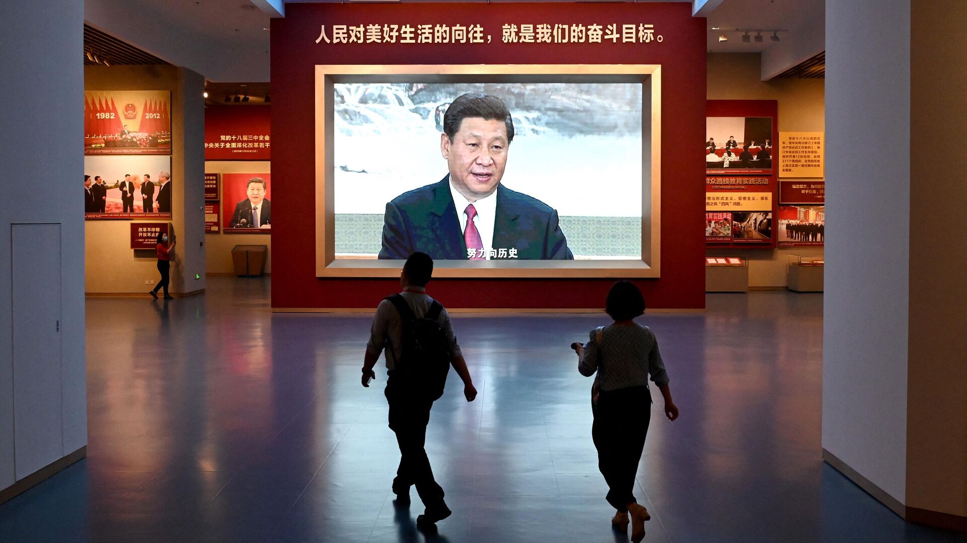 Журналисты проходят мимо экрана с изображением президента Китая Си Цзиньпина во время посещения Музея Коммунистической партии Китая - РИА Новости, 1920, 30.09.2022