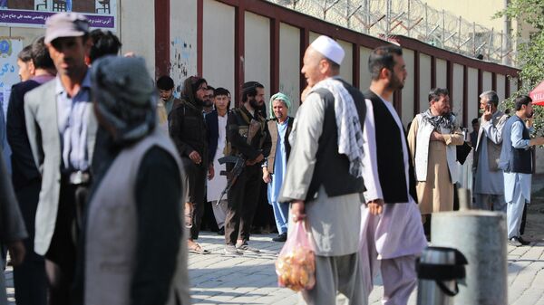 Местные жители возле больницы, куда доставили раненых при взрыве в Кабуле. 30 сентября 2022 года