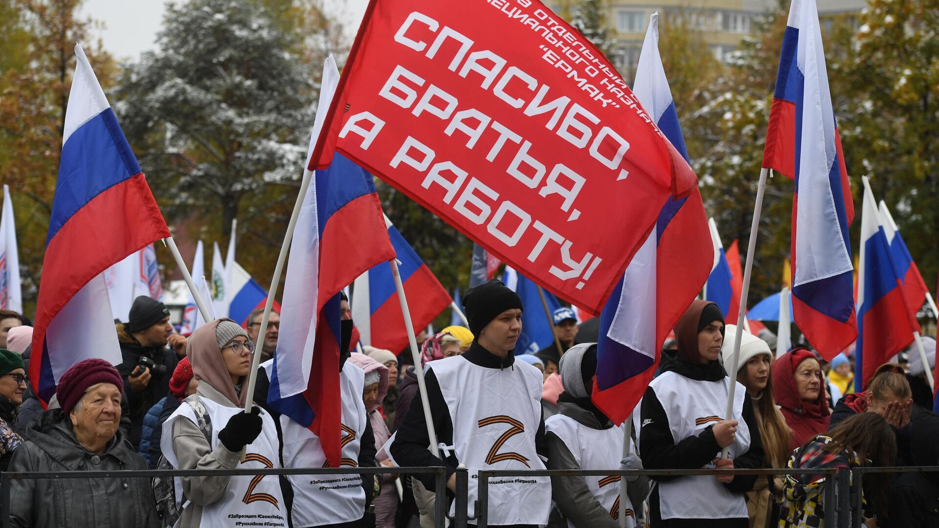 Люди с флагами во время митинга-концерта в честь присоединения ЛНР, ДНР, Херсонской и Запорожской областей к России в Центральном парке Новосибирска - РИА Новости, 1920, 30.09.2022