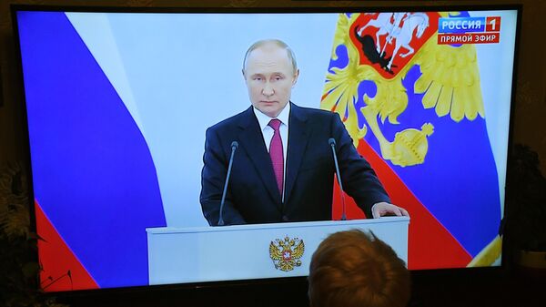 Женщина смотрит телевизионную трансляцию выступления Путина 