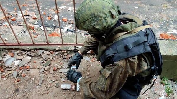 Сотрудник СК РФ проводит осмотр территории в Донецке после артиллерийского обстрела со стороны ВСУ