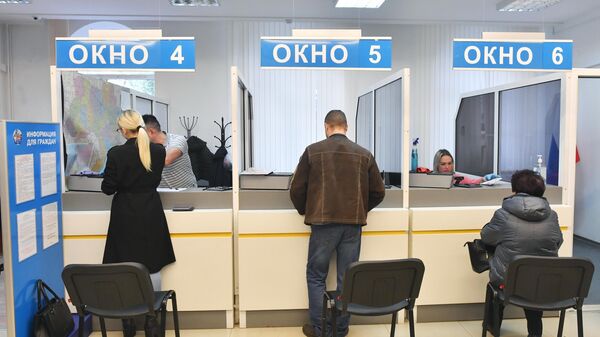 Местные жители ожидают выдачу российских паспортов в миграционной службе МВД ДНР в Донецке
