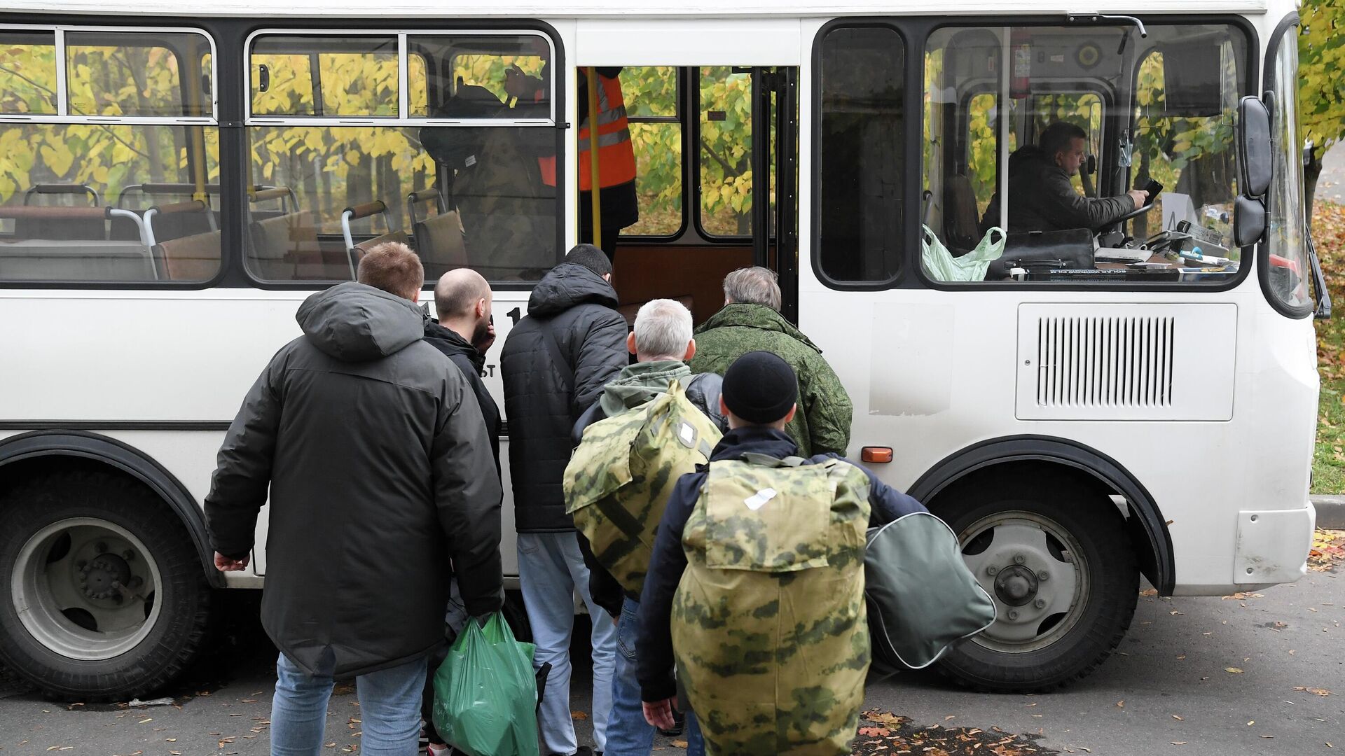 Мужчины, призванные на военную службу в ходе частичной мобилизации, садятся в автобус на территории временного пункта мобилизации в павильоне №46 на ВДНХ в Москве - РИА Новости, 1920, 04.10.2022