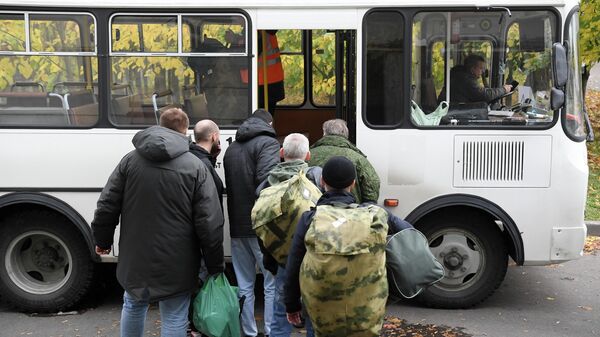 Мужчины, призванные на военную службу в ходе частичной мобилизации, садятся в автобус на территории временного пункта мобилизации в павильоне №46 на ВДНХ в Москве