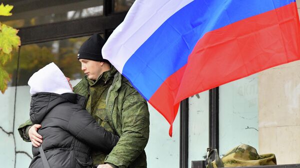 Девушка провожает молодого человека, призванного на военную службу в ходе частичной мобилизации, на территории временного пункта мобилизации в павильоне №46 на ВДНХ в Москве