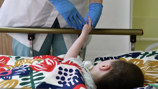 Медицинский работник у кровати пациента первого детского хосписа на базе Свердловской детской областной больницы в Екатеринбурге
