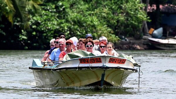 Туристы катаются на моторной лодке по реке Балапития