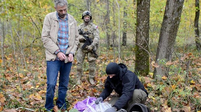 Сотрудник ФСБ России достает взрывное устройство из рюкзака задержанного гражданина Украины, планировавшего совершение диверсионно-террористического акта на одном из транспортно-логистических терминалов в Брянске