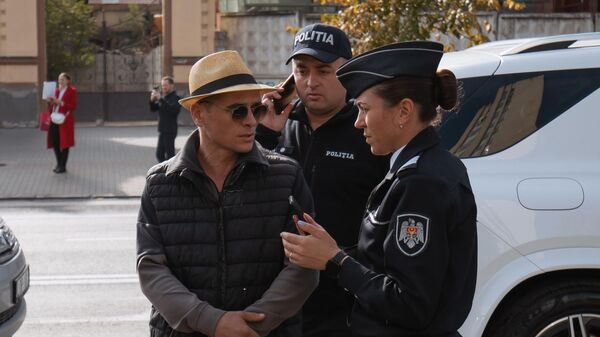 Полицейские задерживают одного из участников акции протеста в Кишиневе