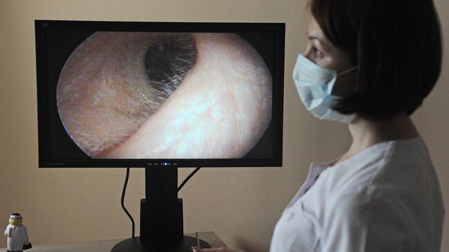 Врач-отоларинголог просматривает запись осмотра уха пациента