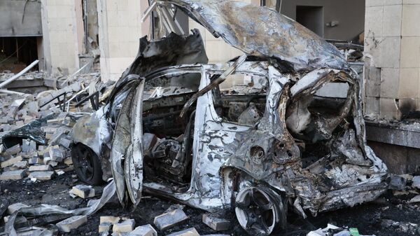 Уничтоженный автомобиль в центре Донецка, поврежденного в результате обстрела со стороны ВСУ