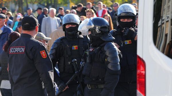 Сотрудники полиции дежурят во время антиправительственной акции протеста, организованной оппозиционной партией Шор, неподалеку от парламента Молдовы в Кишиневе