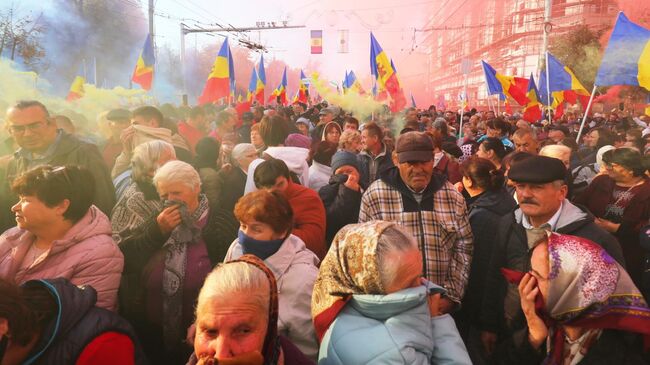 Участники антиправительственной акции протеста, организованной оппозиционной партией Шор, неподалеку от парламента Молдовы в Кишиневе