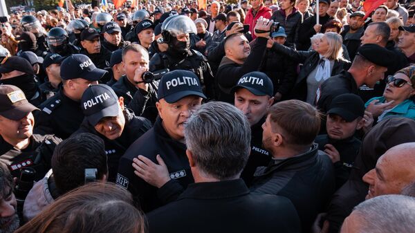 Полицейский общается с одним из участников антиправительственной акции протеста, организованной оппозиционной партией Шор