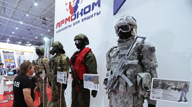 Посетитель Международного военно-технического форума осматривает средства индивидуальной защиты компании Армоком